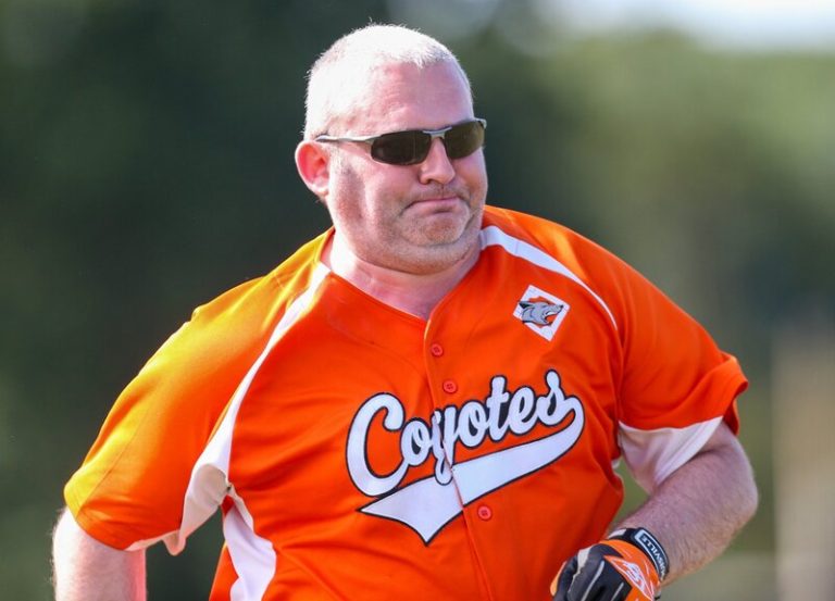 Portrait of Danny in an orange Coyotes jersey, smiling broadly while running on a sunny field