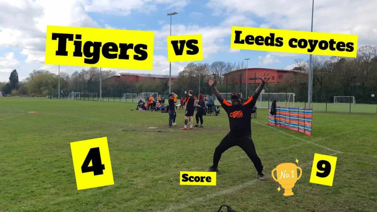 Player named Bobby striking a dramatic superhero pose on the softball field in front of a scoreboard showing Tigers vs Leeds C at 4-4
