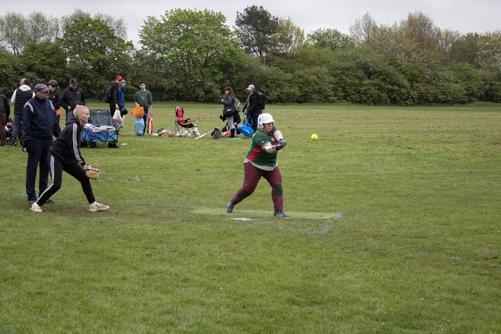 Batting Tee Strong Swing Player in a patterned top taking a strong swing at the batting tee, full body rotation and good bat path visible
