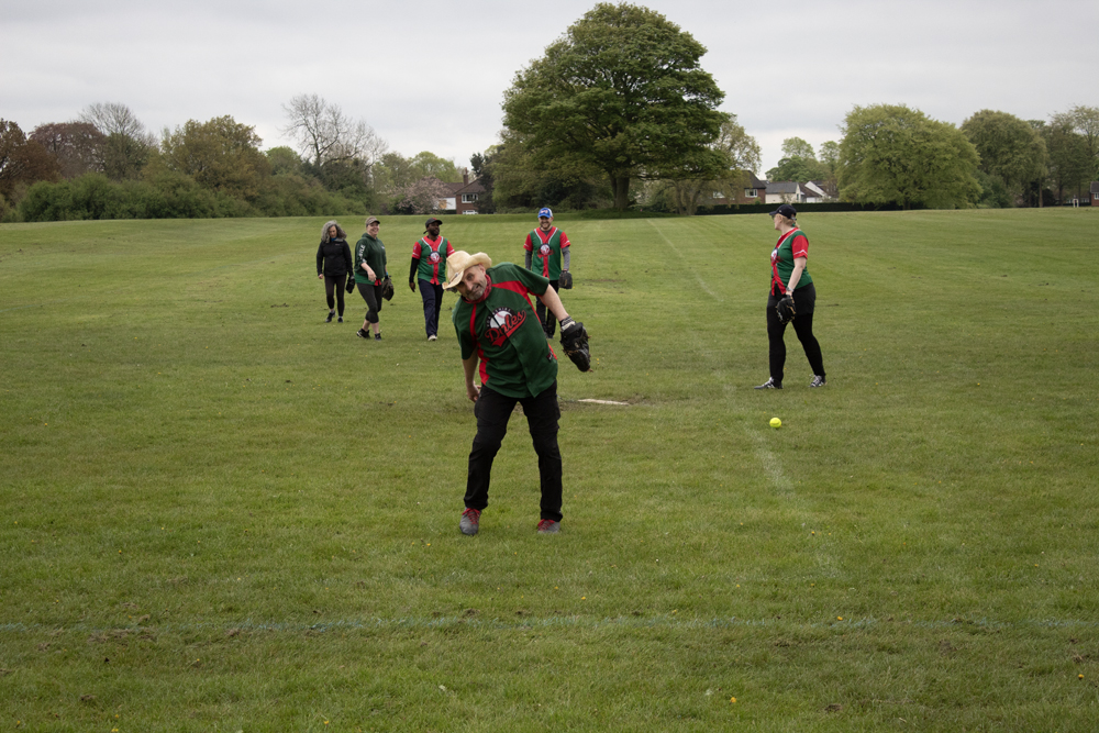 Fielding Drill Warm Up Group of players in mixed kits spread across the field during a fielding warm-up drill on an overcast spring day