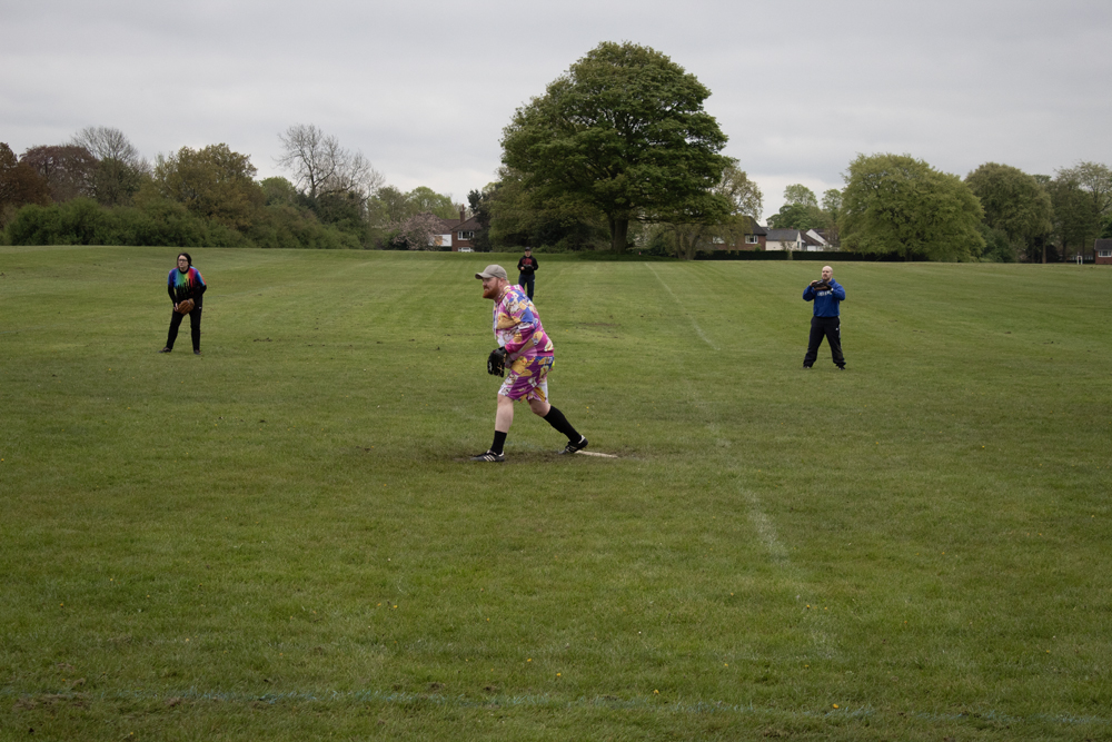 Running Drill Mixed Kit Player in mixed kit running through a drill between bases, another player and coaches visible in the background
