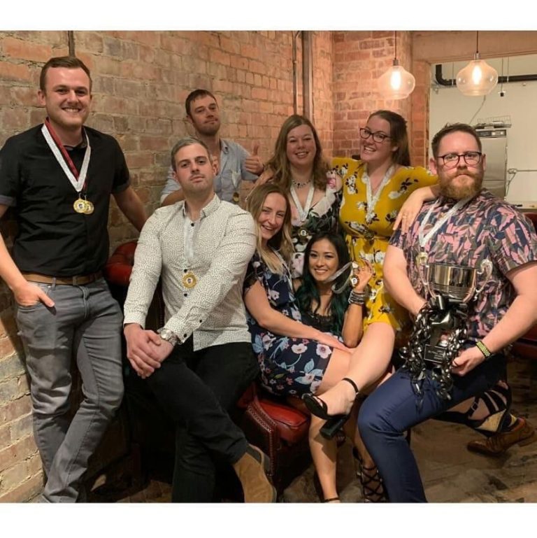 Group of Leeds softball players at a social evening indoors, casually dressed and gathered together