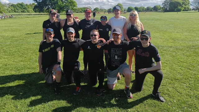 Bad Batch team group photo in black kits, players in kneeling and standing rows on a grass field