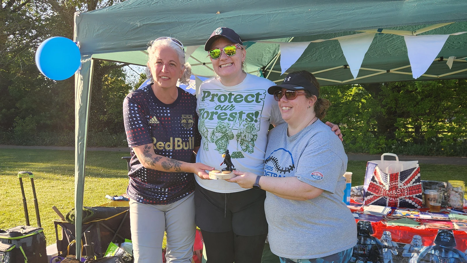 Three Cheeze team members collecting their prize under a marquee at the Leeds tournament ceremony