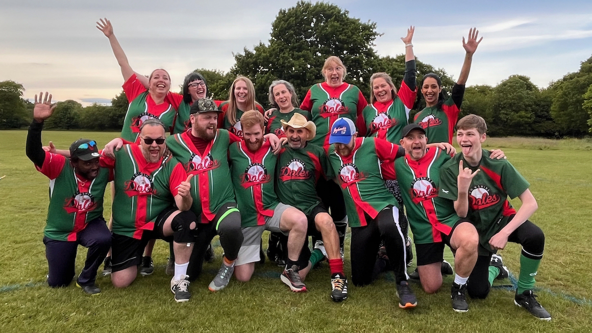 Dales league team 2025 in a fun and silly group pose, everyone in green and red kits laughing on a grass field