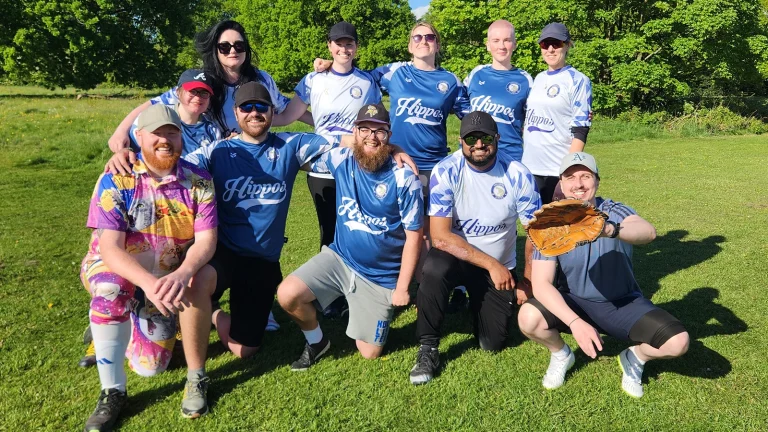Hippos team group photo in blue and white Hippos kits, players posed in kneeling and standing rows in front of trees