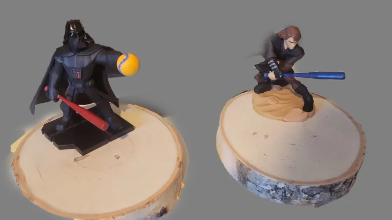 Two custom softball tournament trophy figurines on wooden bases, depicting players in batting and fielding poses
