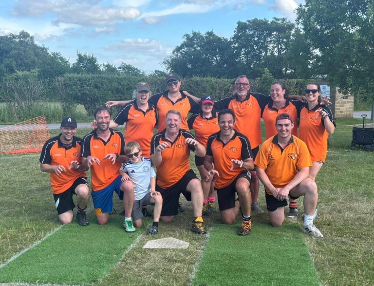 Tigers softball team in orange kit group photo