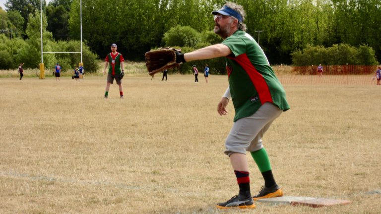 Yorkshire Dales fielder in green and red kit reaching out with a glove to make a catch